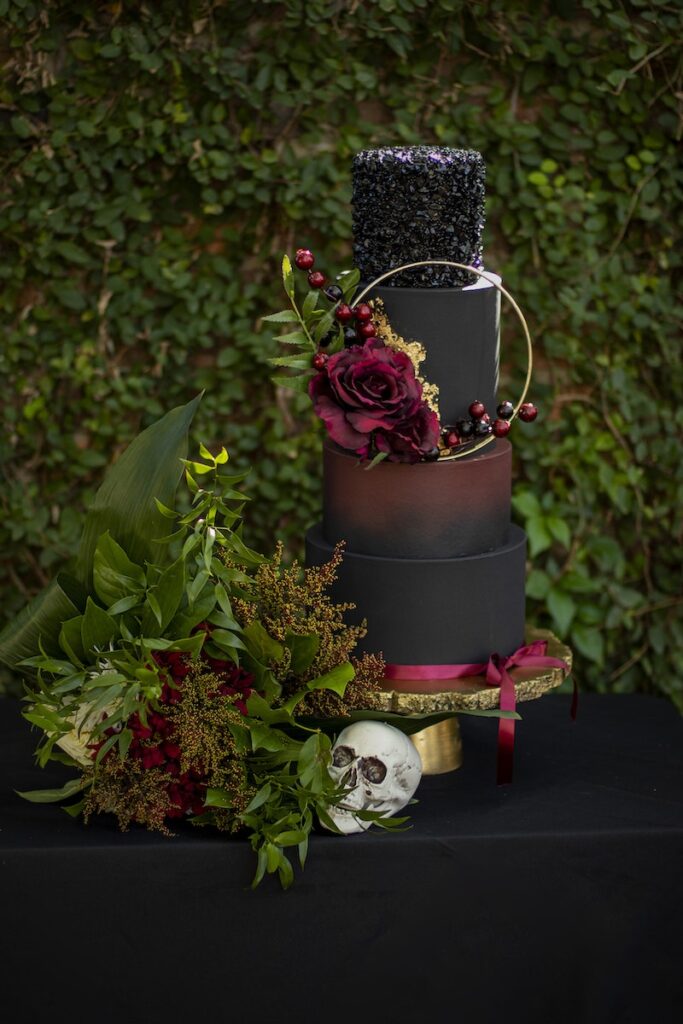 An Artistic Set-up Of A Halloween Decor With Leaves Flowers Skull And a Tier Of Painted Containers